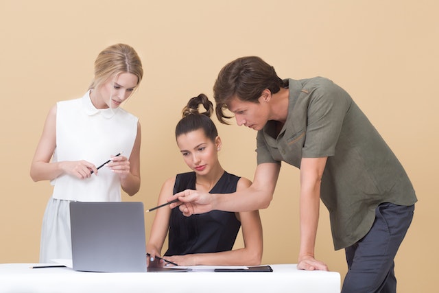 People discussing an issue in front of a laptop