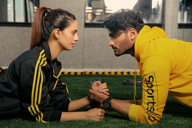 A man and a woman arm wrestle