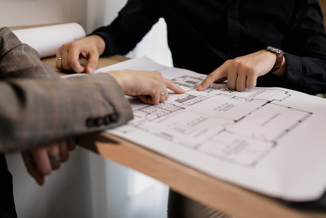 Two people discussing an architectural drawing