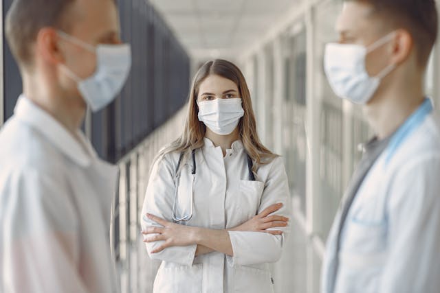 3 Student doctors stand talking in a corridor