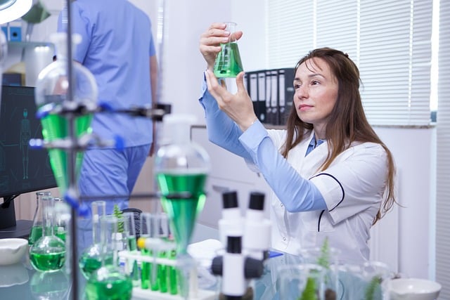 A woman pretends to look at a green 'scientific' fluid in a conical flask.