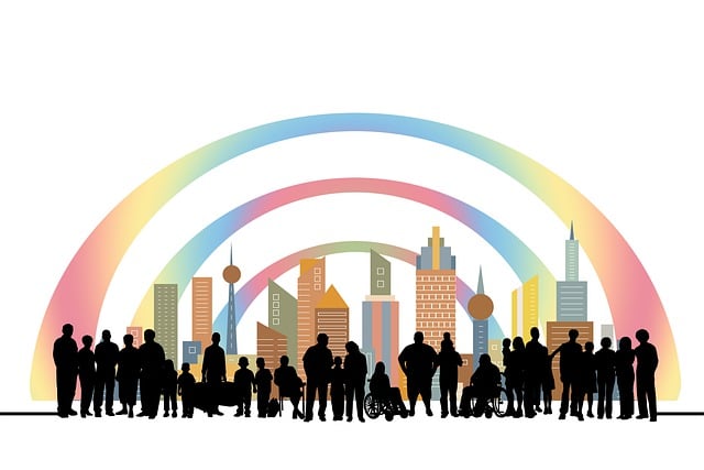 A rainbow over a city with a diverse population in silhouette in front.