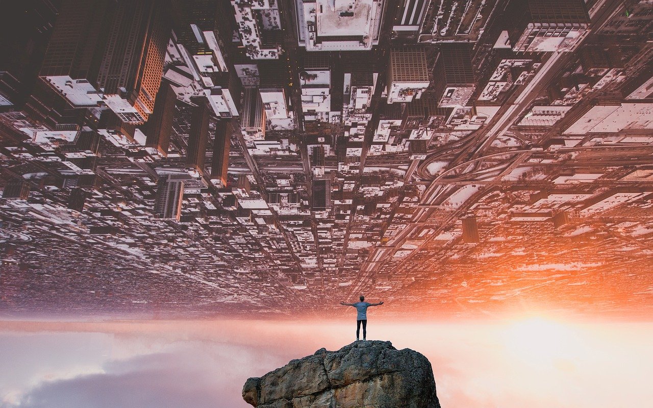 Inverted futuristic cityscape with a man in a rock