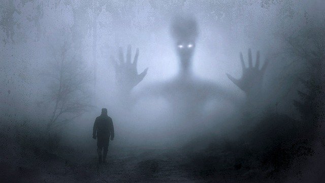 Foggy image of a monster with a man in the foreground