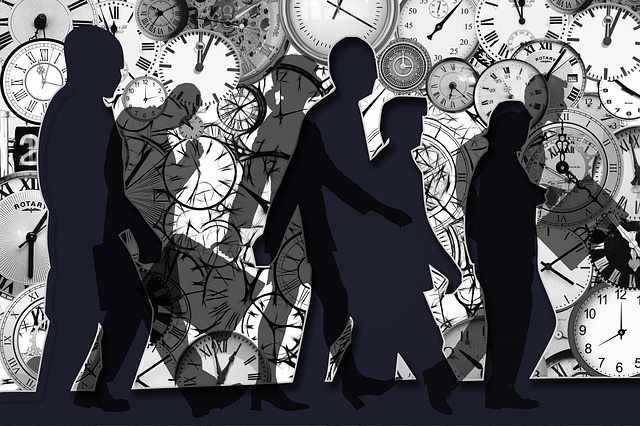 People in silhouette walking against a background of clocks