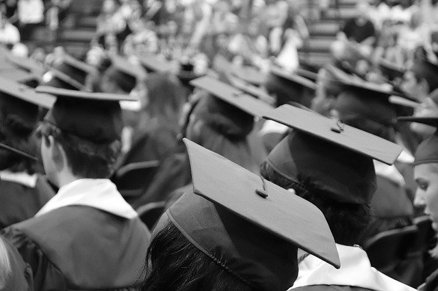 A rear view of many teachers wearing their characteristic hats