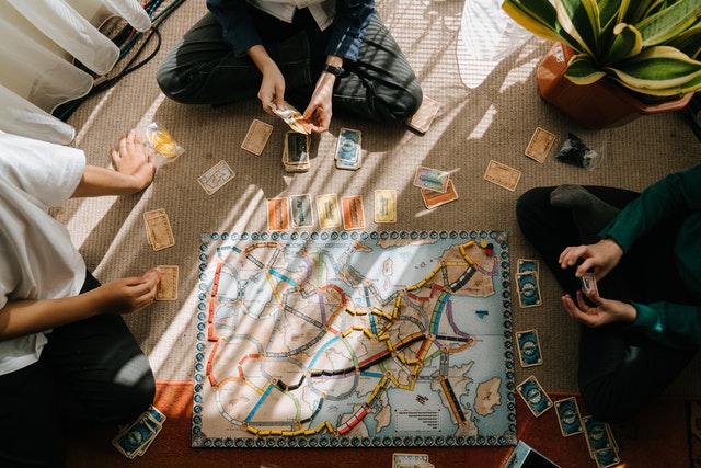 A group of people play a train based board game